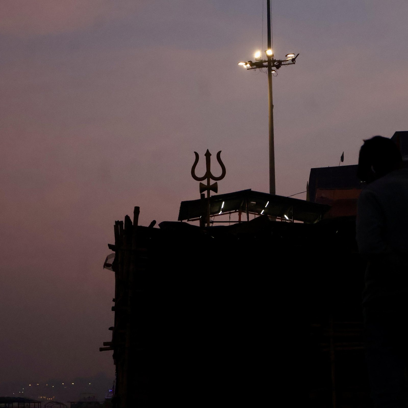 Trident silhouette above the ghat at dusk in Varanasi