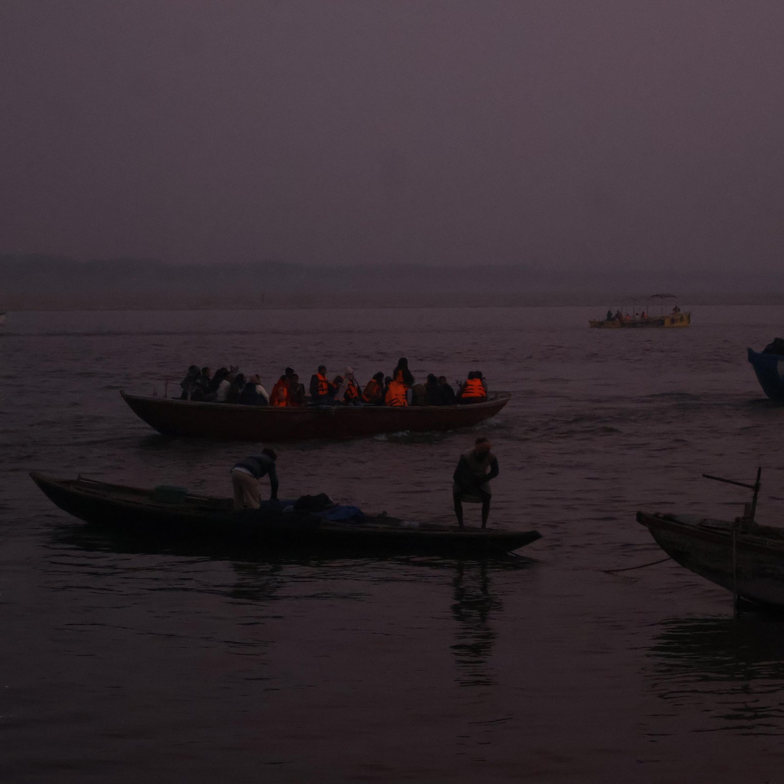 Boats moving across the river at dawn in Varanasi