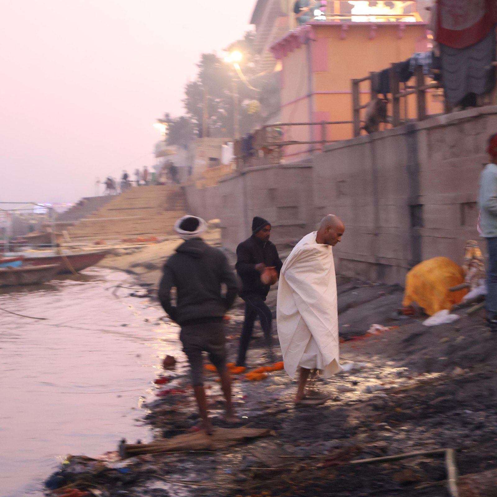 Mourner walking along the river edge near Harishchandra Ghat